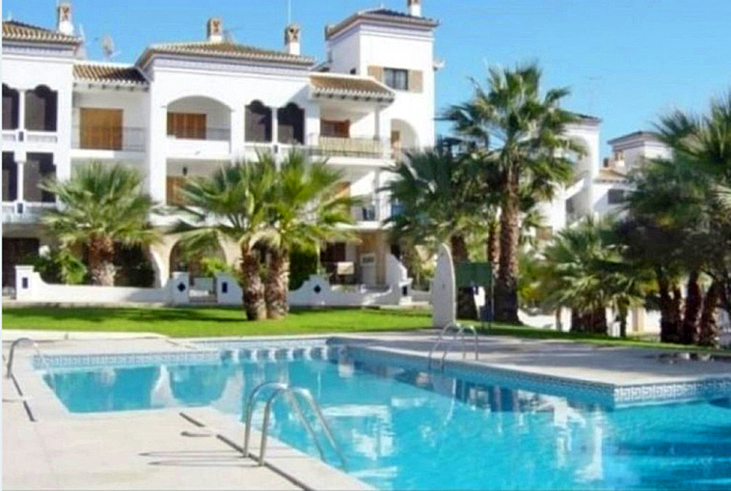 imponujący basen przed apartamentowcem, w którym znajduje się oferowany na sprzedaż luksusowy apartament Hiszpania (Costa Blanca, Orihuela Costa)