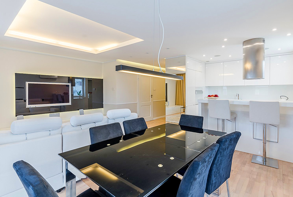 na pierwszym planie jadalnia, w oddali kuchnia w ekskluzywnym apartamencie do sprzedaży Gdańsk