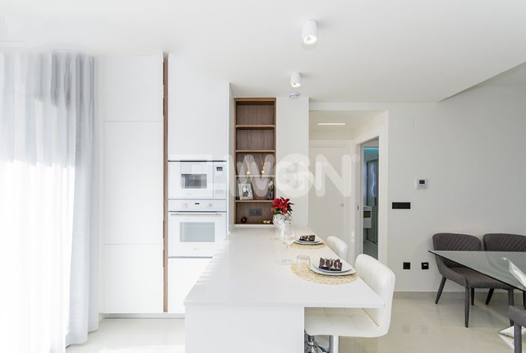 na pierwszym planie jadalnia oraz kuchnia w luksusowym apartamencie na sprzedaż Hiszpania (Torrevieja, Alicante)