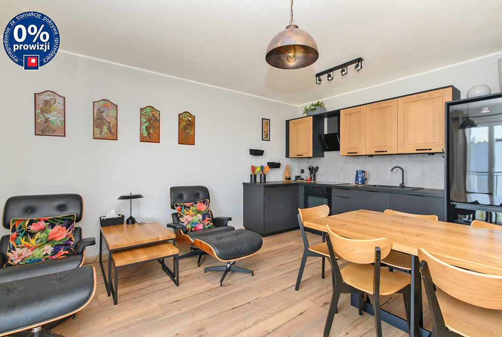 na pierwszym planie jadalnia, w oddali aneks kuchenny w luksusowym apartamencie do sprzedaży Gdynia (okolice)