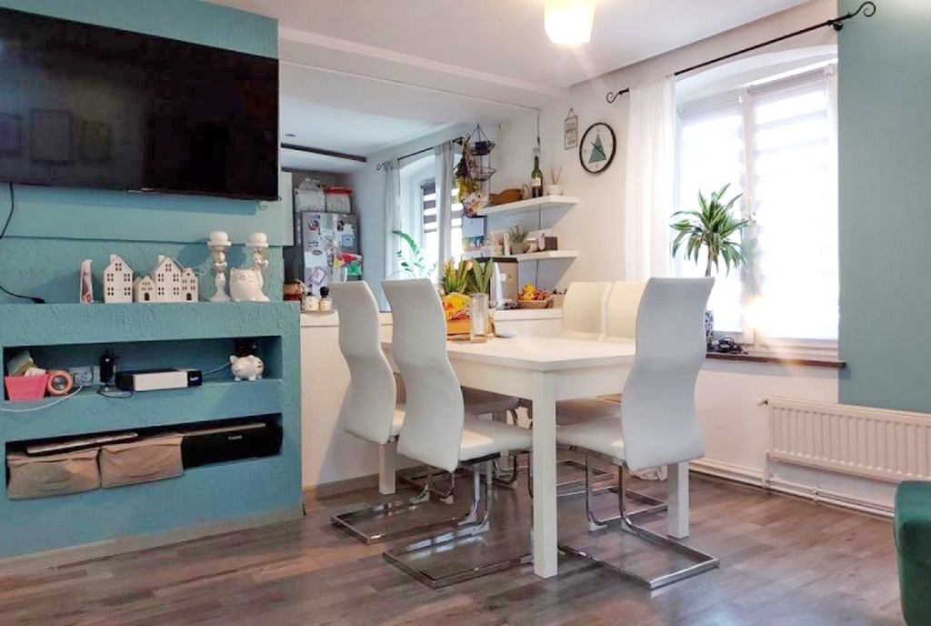 na pierwszym planie jadalnia, w oddali kuchnia w luksusowym apartamencie do sprzedaży Żagań (okolice)