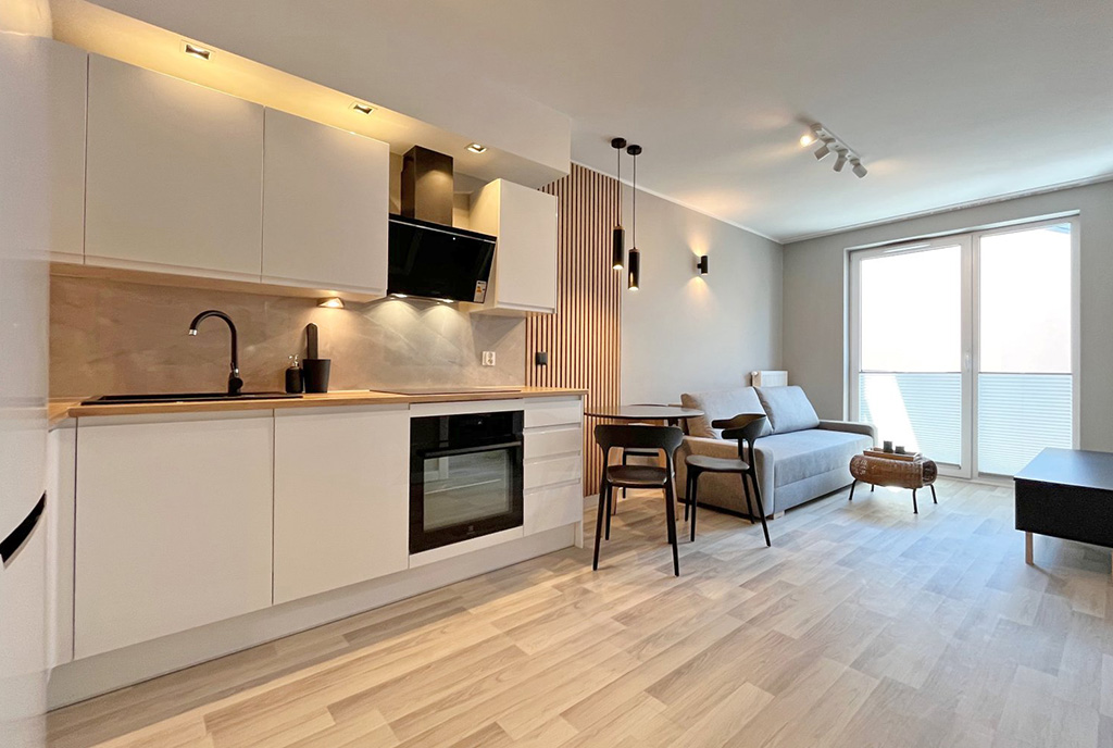 widok na salon oraz balkon w luksusowym apartamencie do wynajmu Szczecin