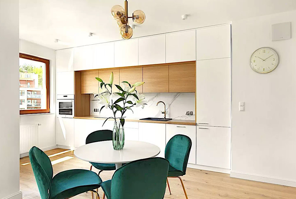 jadalnia, a za nią aneks kuchenny w ekskluzywnym apartamencie na sprzedaż Gdynia