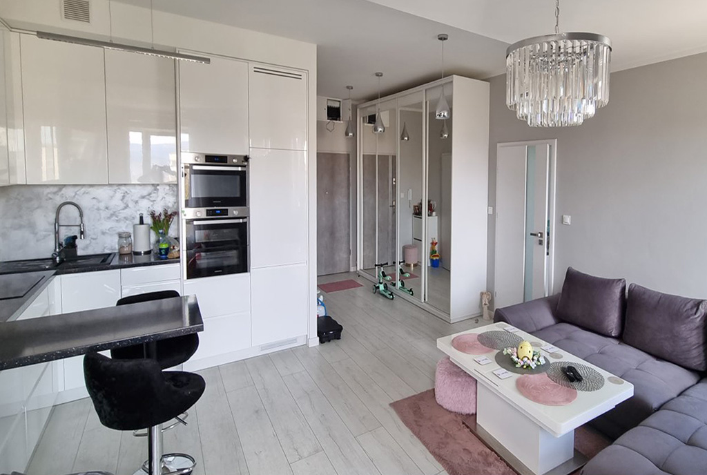na pierwszym planie kuchnia i jadalnia w luksusowym apartamencie na sprzedaż Kłodzko