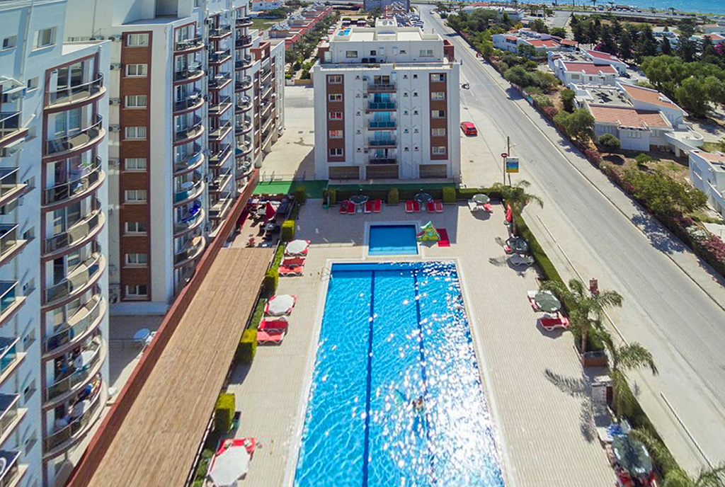 widok na basen w częściach wspólnych z okna oferowanego na sprzedaż ekskluzywnego apartamentu na sprzedaż Cypr