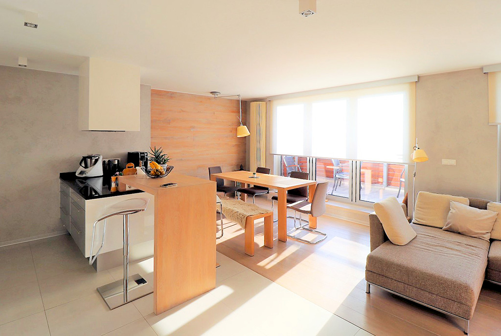 na pierwszym planie kuchnia i jadalnia w luksusowym apartamencie na sprzedaż Ustroń