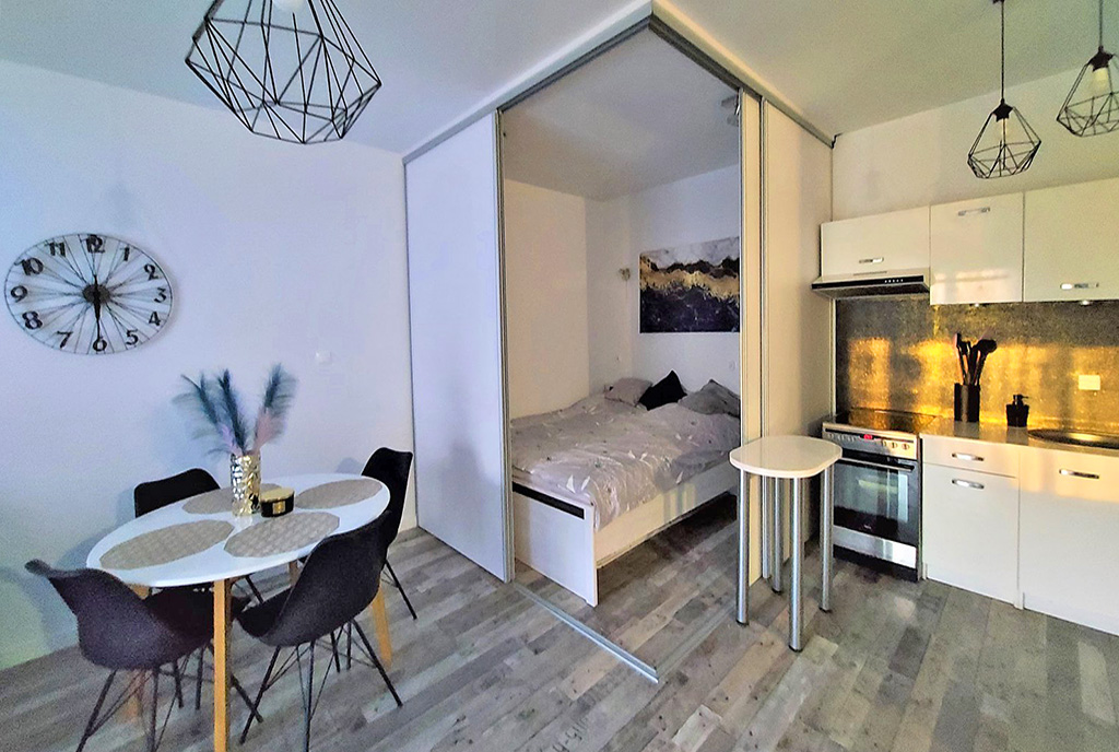 od lewej jadalnia, sypialnia i aneks kuchenny w luksusowym apartamencie do wynajmu Łódź