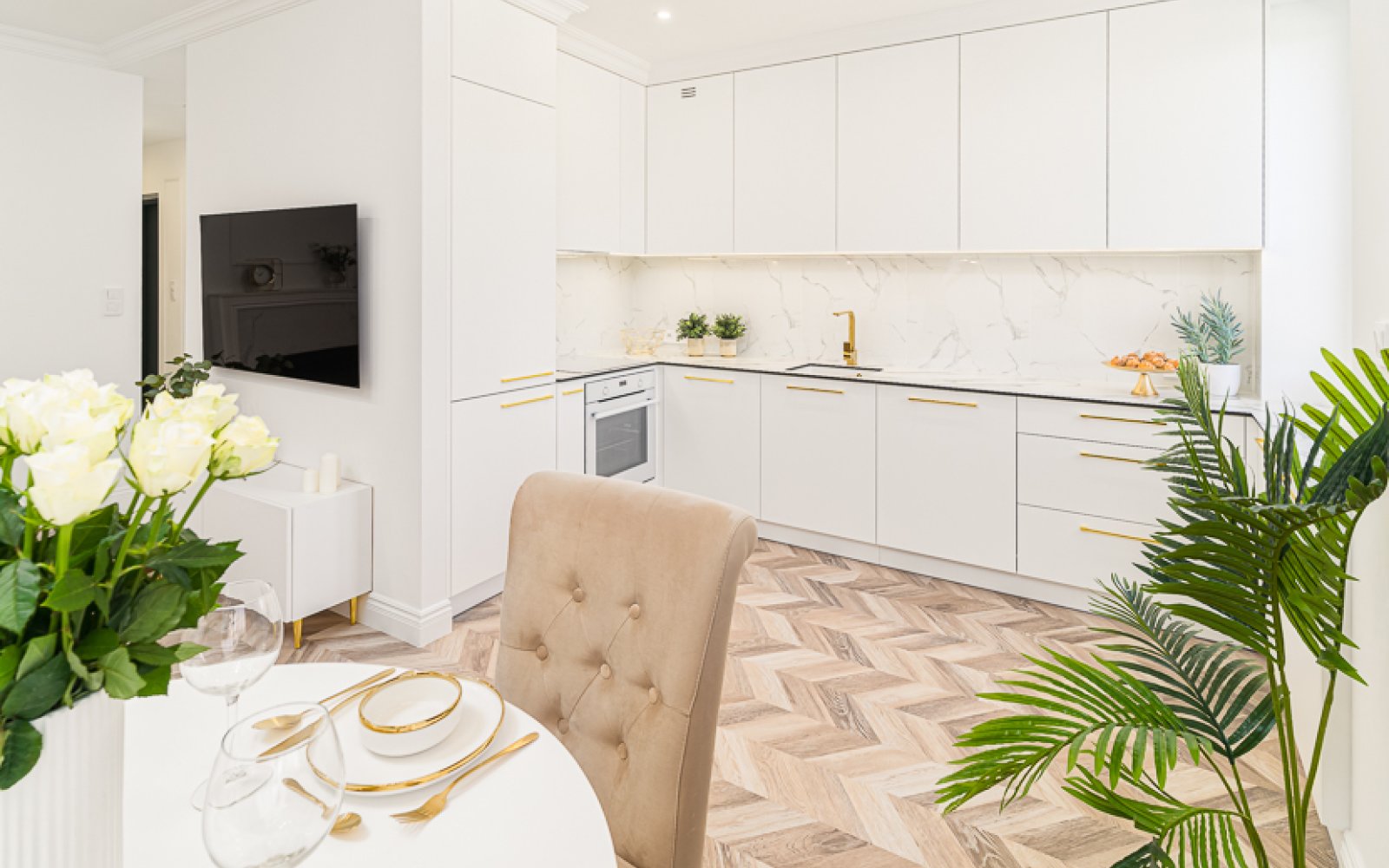 na pierwszym planie jadalnia, w oddali kuchnia w luksusowym apartamencie na sprzedasż Łódź