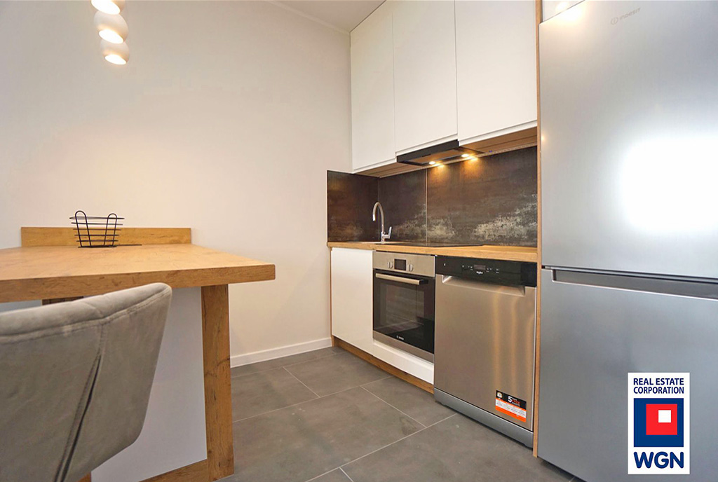 widok z pokoju gościnnego na aneks kuchenny w ekskluzywnym apartamencie na wynajem Konin