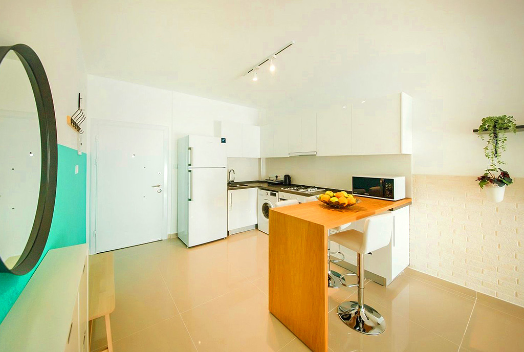zdjęcie prezentuje jadalnię oraz kuchnię w luksusowym apartamencie do sprzedaży Cypr (Iskele)