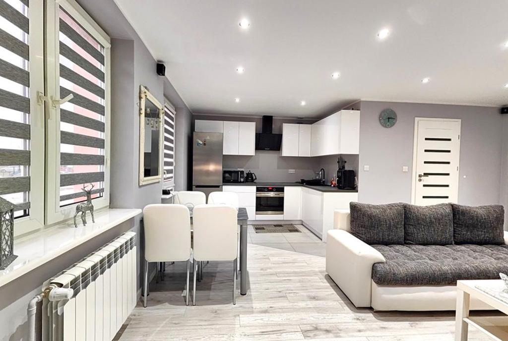 po lewej jadalnia, po prawej salon w luksusowym apartamencie na sprzedaż Mazury