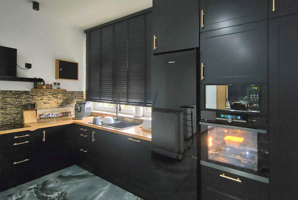 czarna kolorystyka kuchni w ekskluzywnym apartamencie na wynajem Szczecin (okolice)