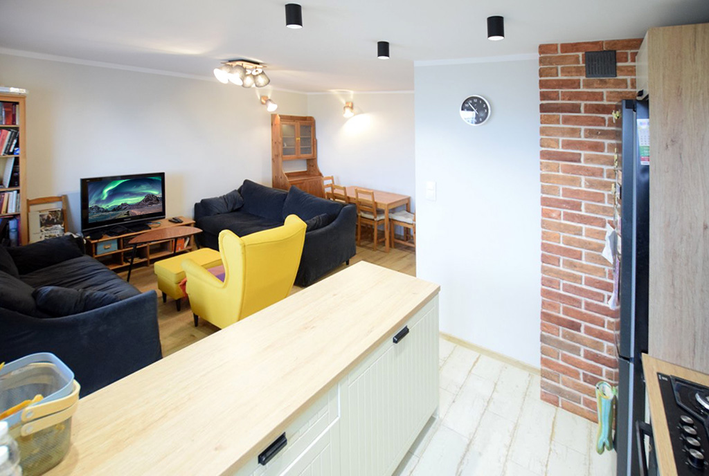na pierwszym planie aneks kuchenny, w oddali salon w luksusowym apartamencie do wynajmu Suwałki