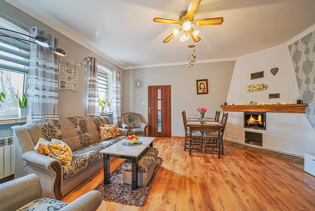 widok na elegancki kominek w wytwornym pokoju dziennym luksusowego apartamentu na sprzedaż Legnica (okolice)