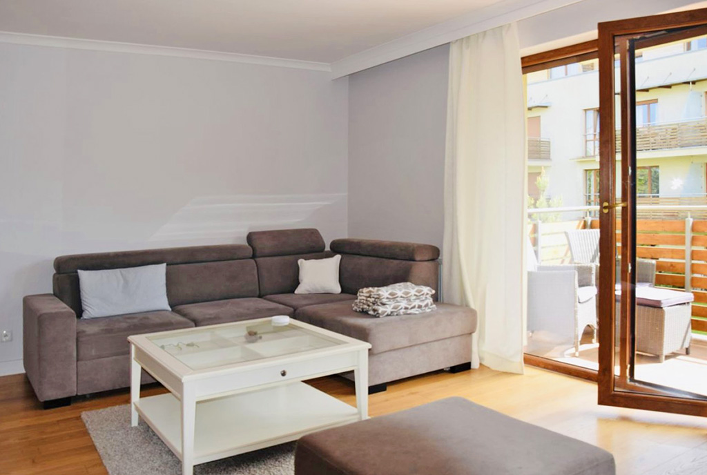 zbliżenia na salon i fragment tarasu przy luksusowym apartamencie do wynajmu Ustka