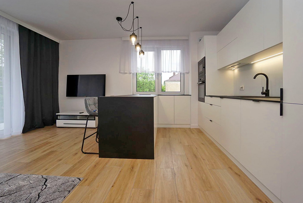po prawej kuchnia, po lewej salon w luksusowym apartamencie do wynajmu Piotrków Trybunalski