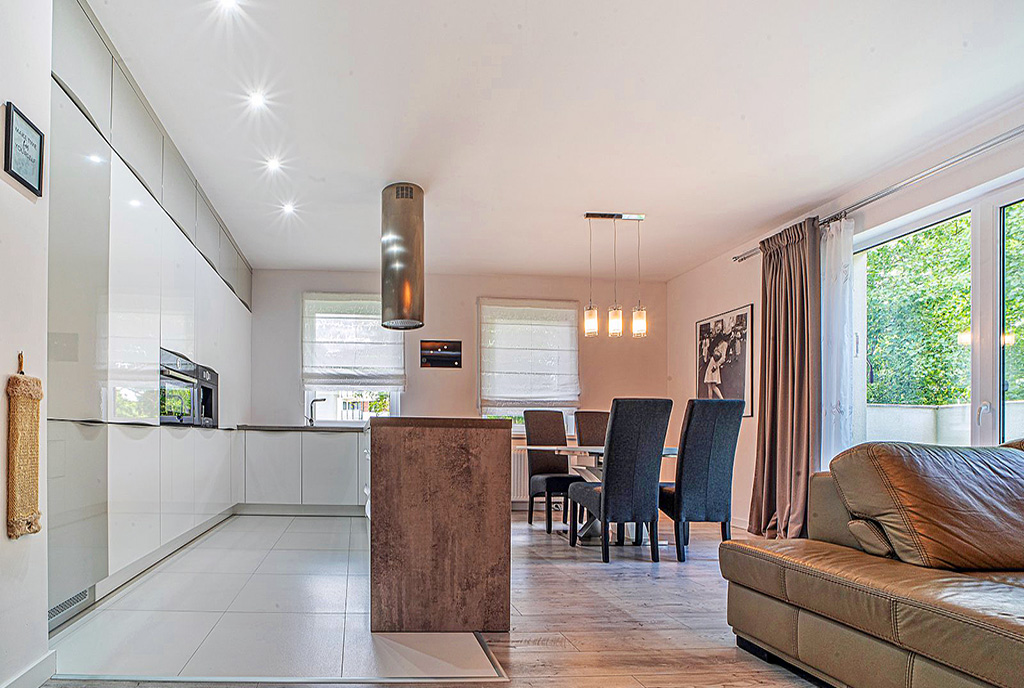 po lewej aneks kuchenny, po prawej salon w luksusowym apartamencie na wynajem Bolesławiec