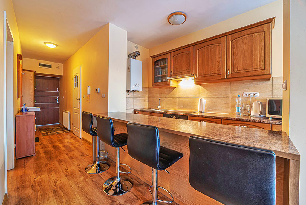 zaaranżowany we współczesnym designie aneks kuchenny z jadalnią w luksusowym apartamencie na sprzedaż Bolesławiec