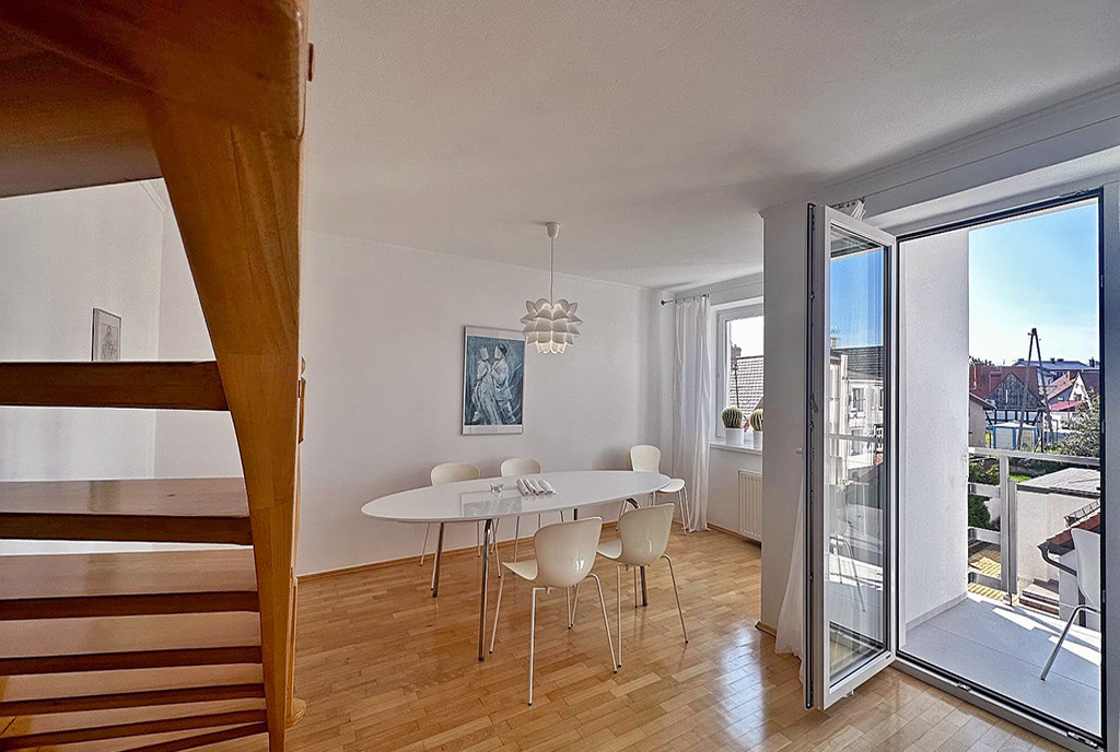 pokój dzienny z wyjściem na taras przy luksusowym apartamencie do wynajmu nad morzem