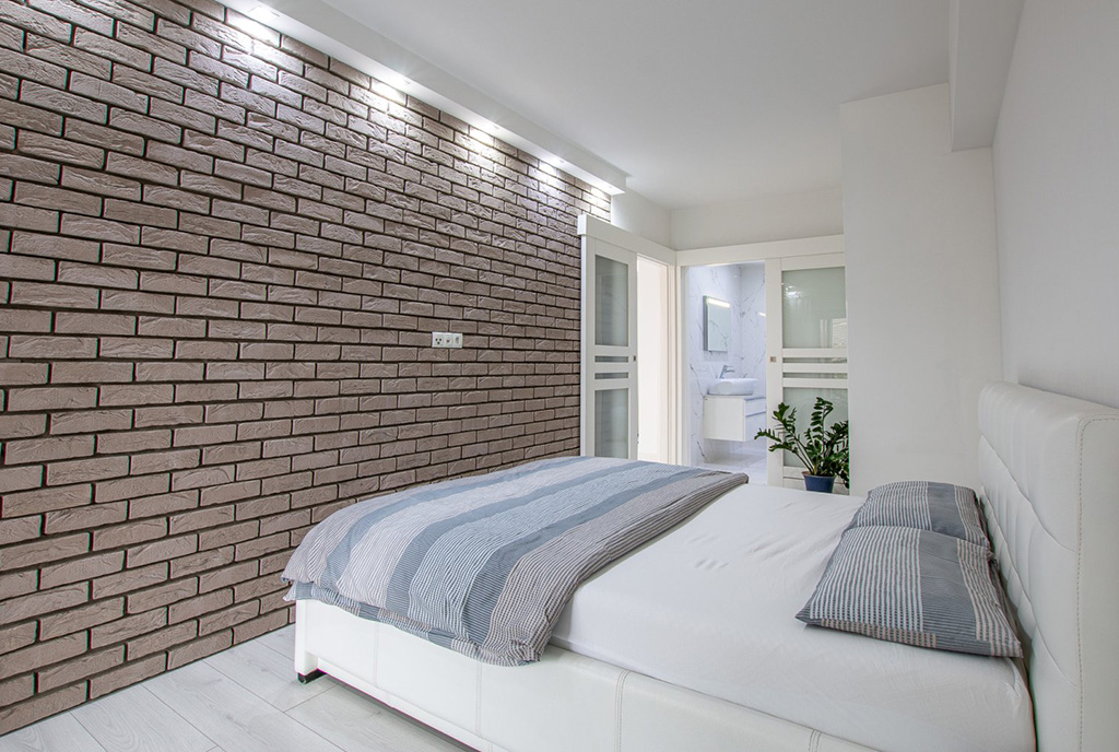 efektownie oświetlona sypialnia w ekskluzywnym apartamencie na sprzedaż Poznań
