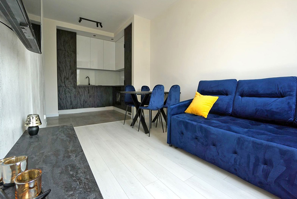na pierwszym planie salon, w oddali kuchnia w luksusowym apartamencie do wynajmu Piotrków Trybunalski