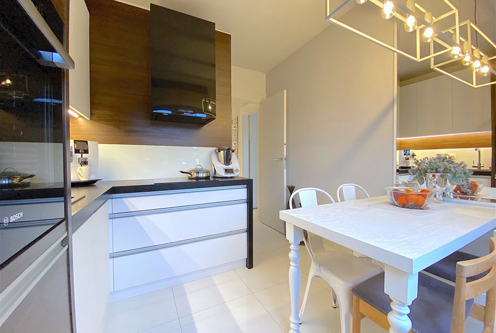 po lewej kuchnia, po prawej jadalnia w ekskluzywnym apartamencie na sprzedaż Szczecin (okolice)
