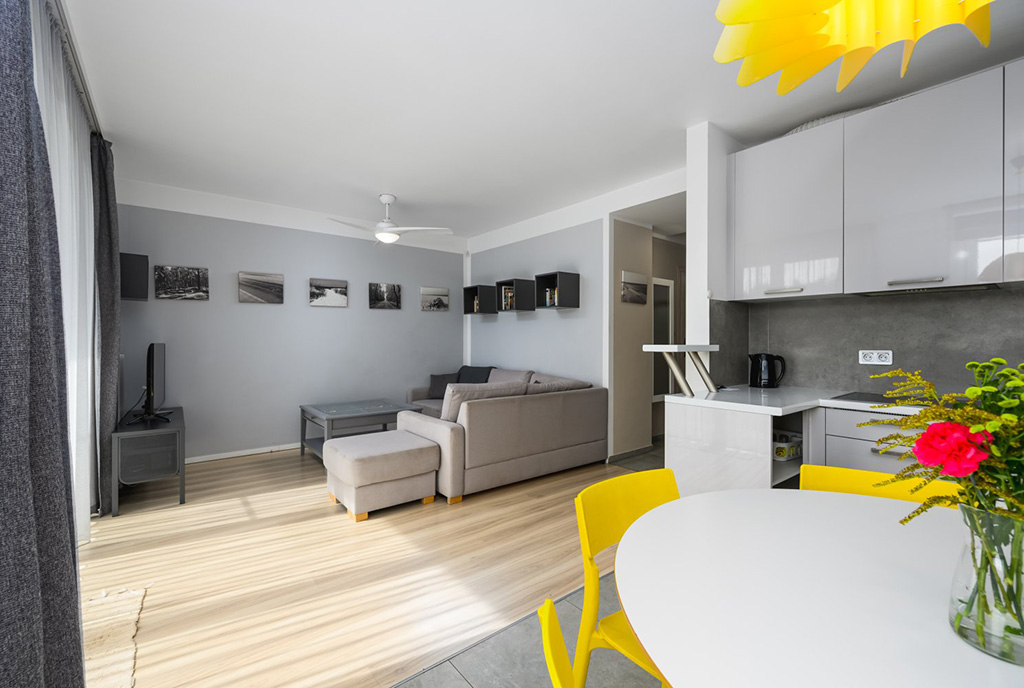 na pierwszym planie jadalnia, w oddali salon w luksusowym apartamencie na sprzedaż Gdańsk