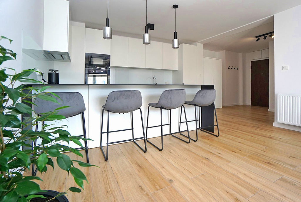 na pierwszym planie aneks kuchenny z wyspą w luksusowym apartamencie do wynajmu Piotrków Trybunalski