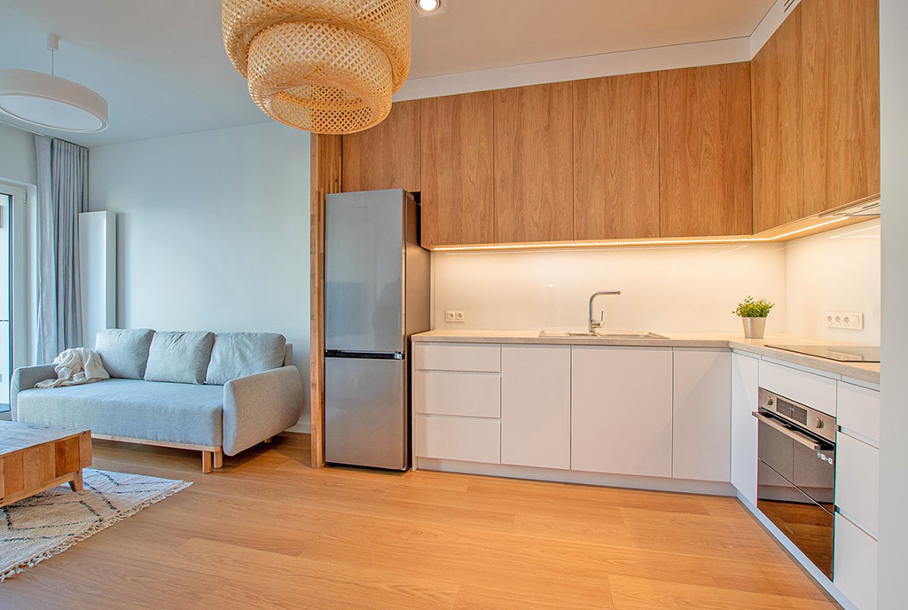 widok na kuchnię i pokój dzienny w ekskluzywnym apartamencie na wynajem Poznań