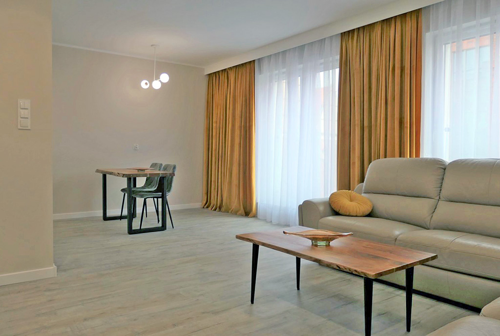 na zdjęciu pokój gościnny w luksusowym apartamencie na sprzedaż Elbląg