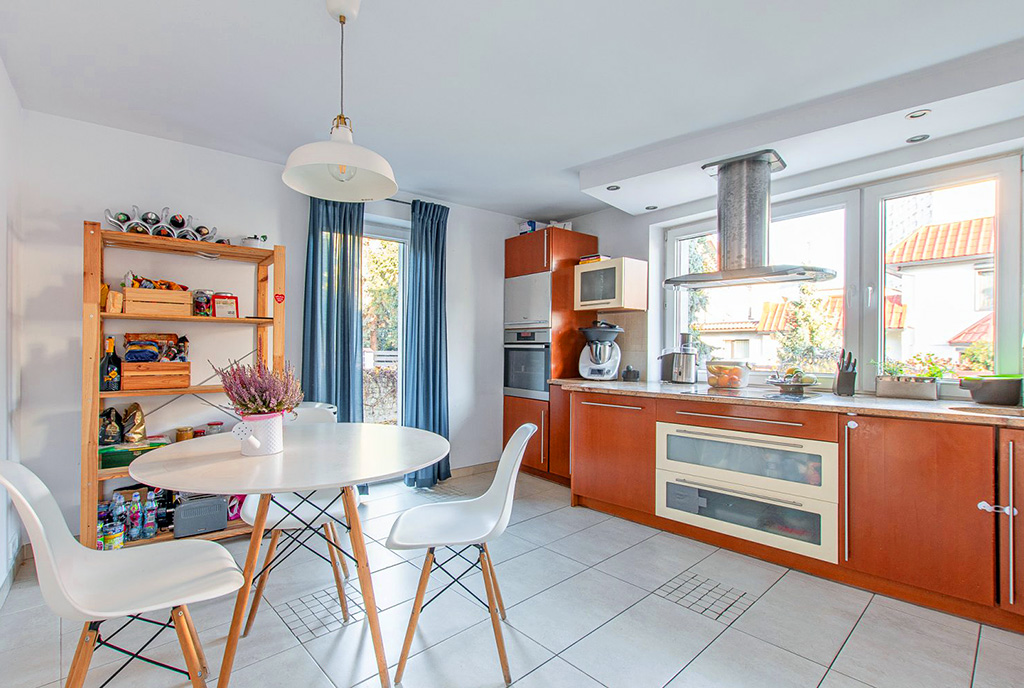 zdjęcie prezentuje elegancką kuchnię i jadalnię w luksusowej willi na sprzedaż Poznań