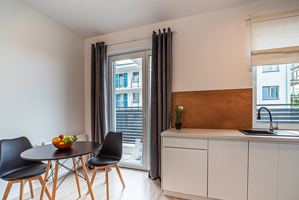 po lewej jadalnia, po prawej kuchnia w luksusowym apartamencie do wynajmu Bolesławiec