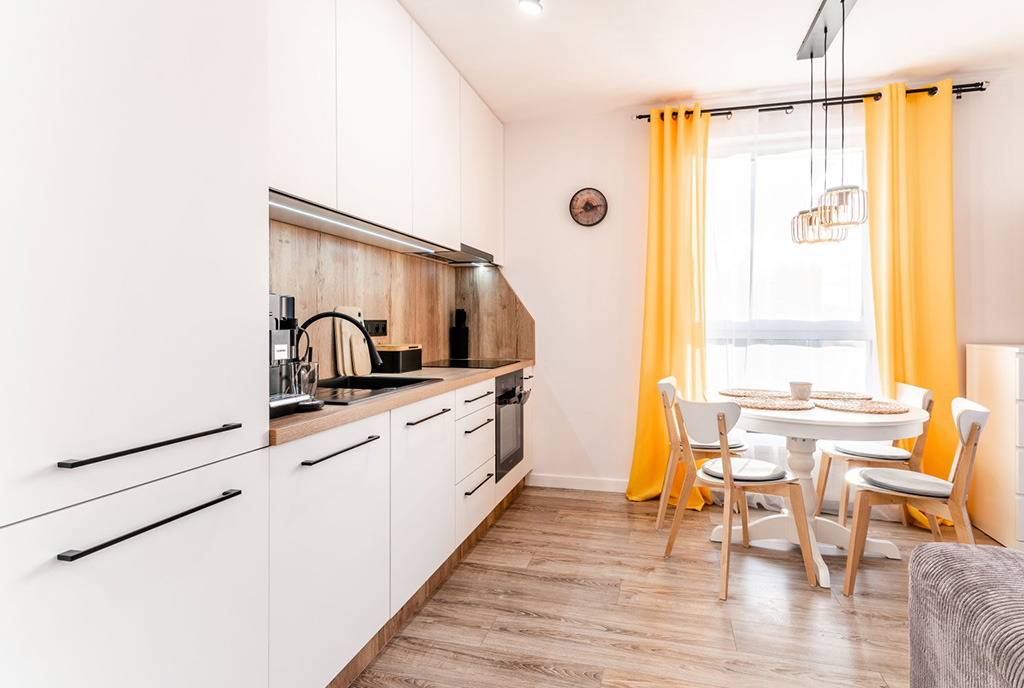 po lewej kuchnia, po prawej salon w luksusowym apartamencie do wynajmu Gdynia (okolice)