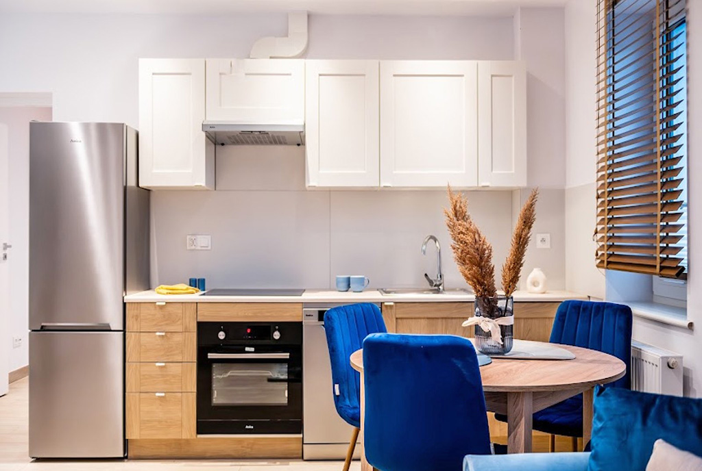 na pierwszym planie jadalnie, w oddali kuchnia w ekskluzywnym apartamencie na sprzedaż Gdynia (okolice)