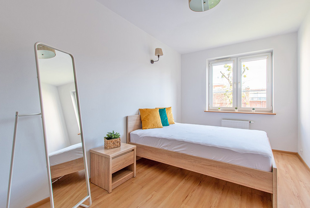 utrzymana w bieli sypialnia w ekskluzywnym apartamencie na wynajem Poznań
