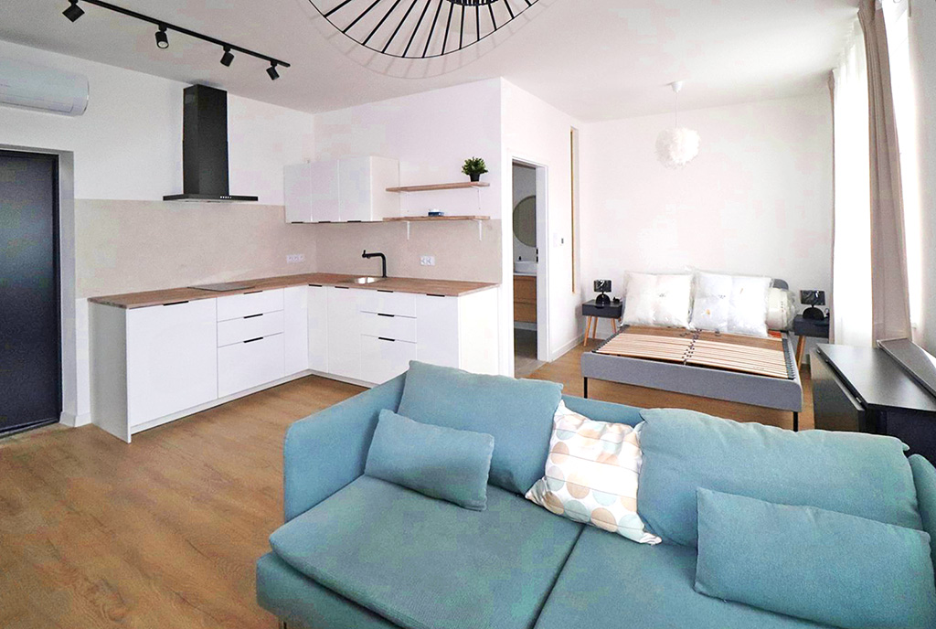 na pierwszynm planie salon, w oddali aneks kuchenny w luksusowym apartamencie na sprzedaż Ustroń