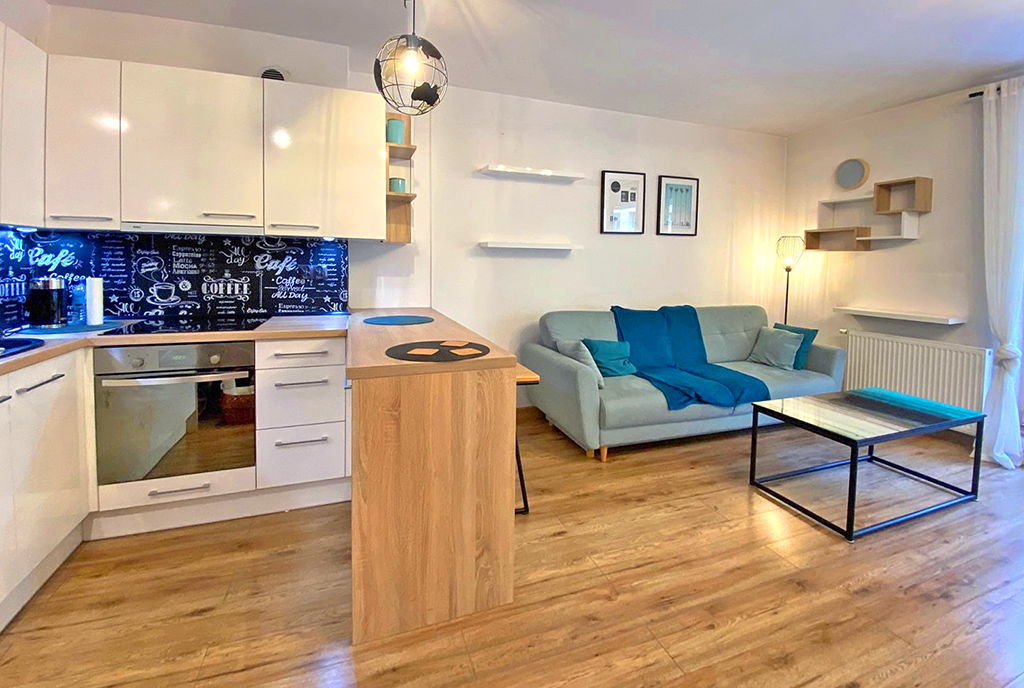 po lewej kuchnia, po prawej salon w ekskluzywnym apartamencie do wynajęcia Szczecin