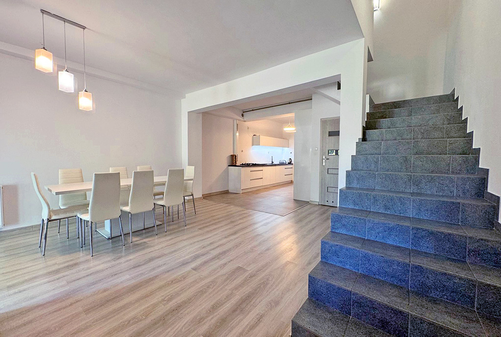 po lewej jadalnia, po prawej schody w ekskluzywnym apartamencie na sprzedaż nad morzem