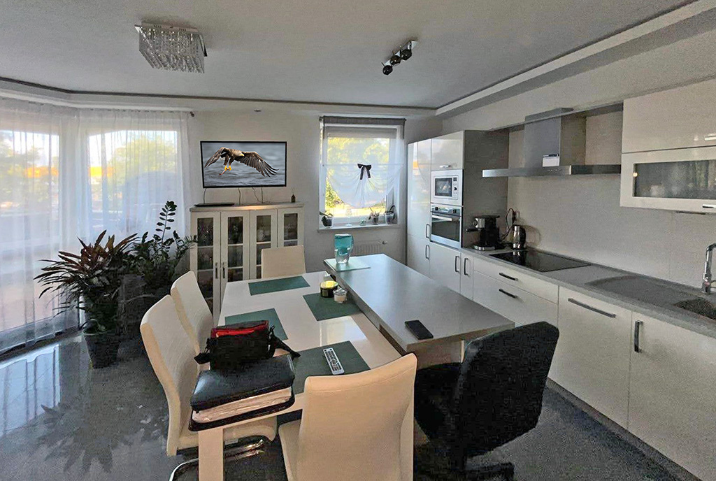 na pierwszym planie jadalnia, w oddali kuchnia w luksusowym apartamencie na sprzedaż Gorzów Wielkopolski