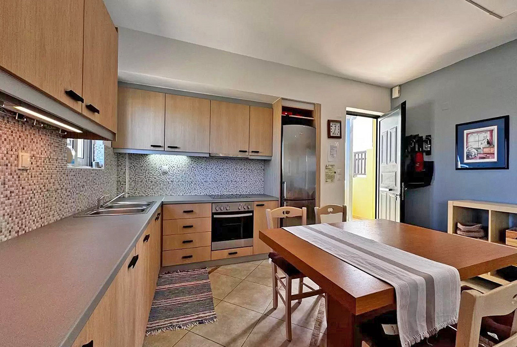 po lewej kuchnia, po prawej jadalnia w luksusowym apartamencie na sprzedaż Grecja
