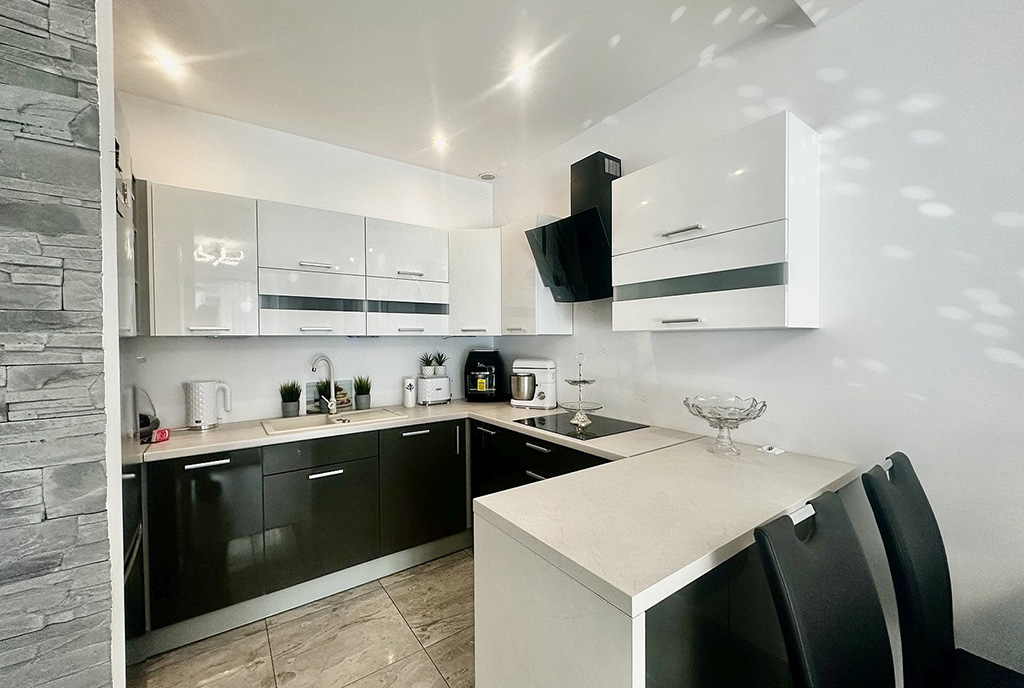 zaprojektowana w czerni i bieli kuchnia w luksusowym apartamencie na sprzedaż Słupsk