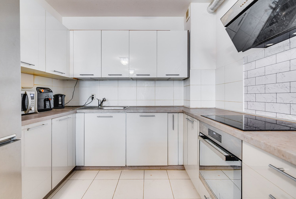 zaprojektowana w bieli kuchnia w ekskluzywnym apartamencie na sprzedaż Gdańsk (okolice)