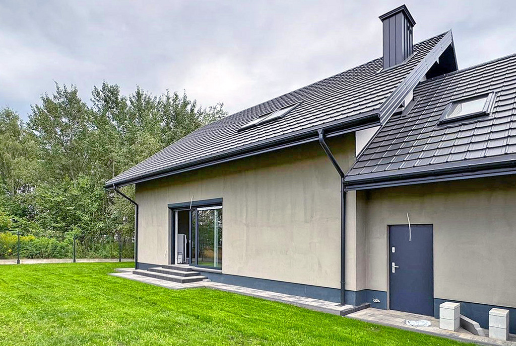 zdjęcie wykonane od strony ogrodu prezentujące bryłę luksusowej willi do sprzedaży Warszawa (okolice)