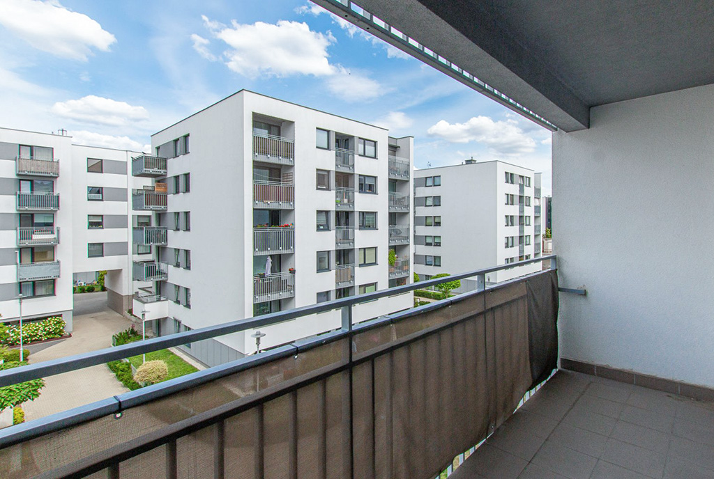 słoneczny balkon z widokiem na osiedle przy luksusowym apartamencie do sprzedaży Poznań