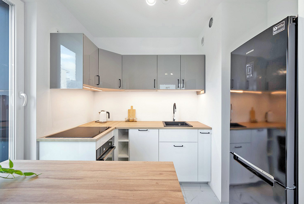 utrzymana w bielach oraz szarościach kuchnia w luksusowym apartamencie na sprzedaż Gdańsk