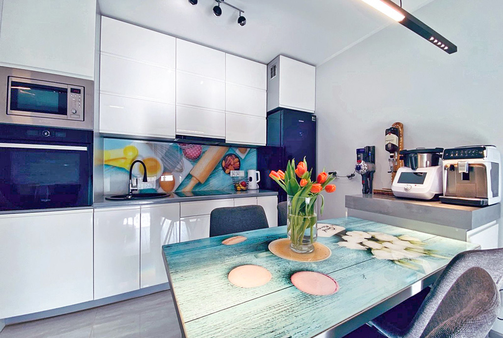 na pierwszym planie jadalnia, w oddali kuchnia w luksusowym apartamencie na sprzedaż Katowice (okolice)