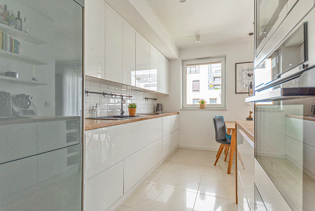 zaprojektowana w bieli kuchnia w luksusowym apartamencie na sprzedaż Poznań