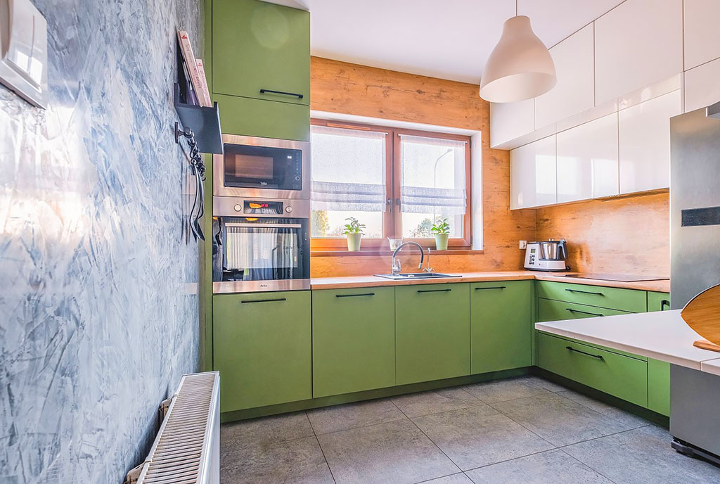 fragment kuchni w zielonym kolorze w ekskluzywnym apartamencie na sprzedaż Poznań (okolice)
