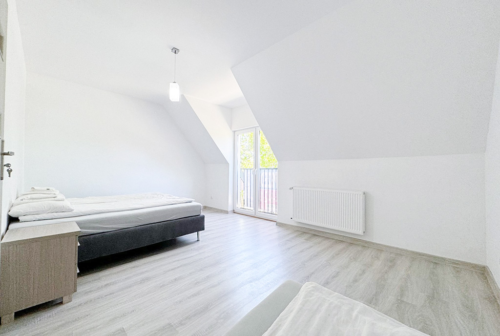 znajdująca się na poddaszu sypialnia w ekskluzywnym apartamencie na sprzedaż nad morzem