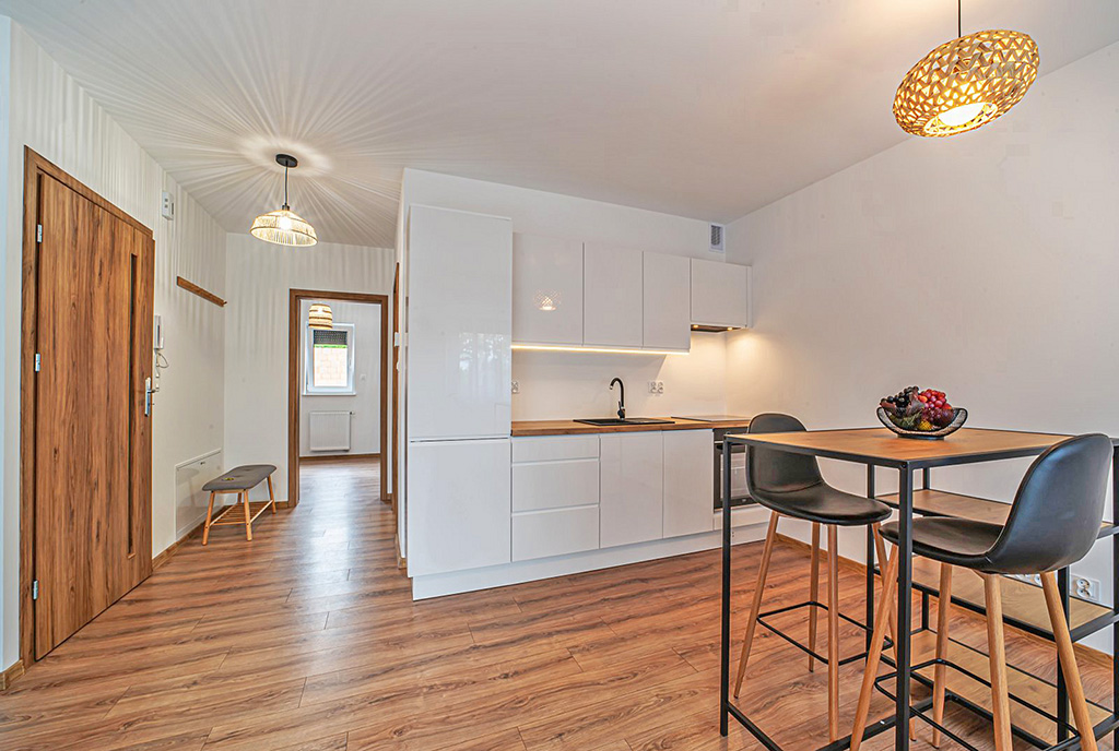 po lewej jadalnia na wprost aneks kuchenny w ekskluzywnym apartamencie na wynajem Bolesławiec